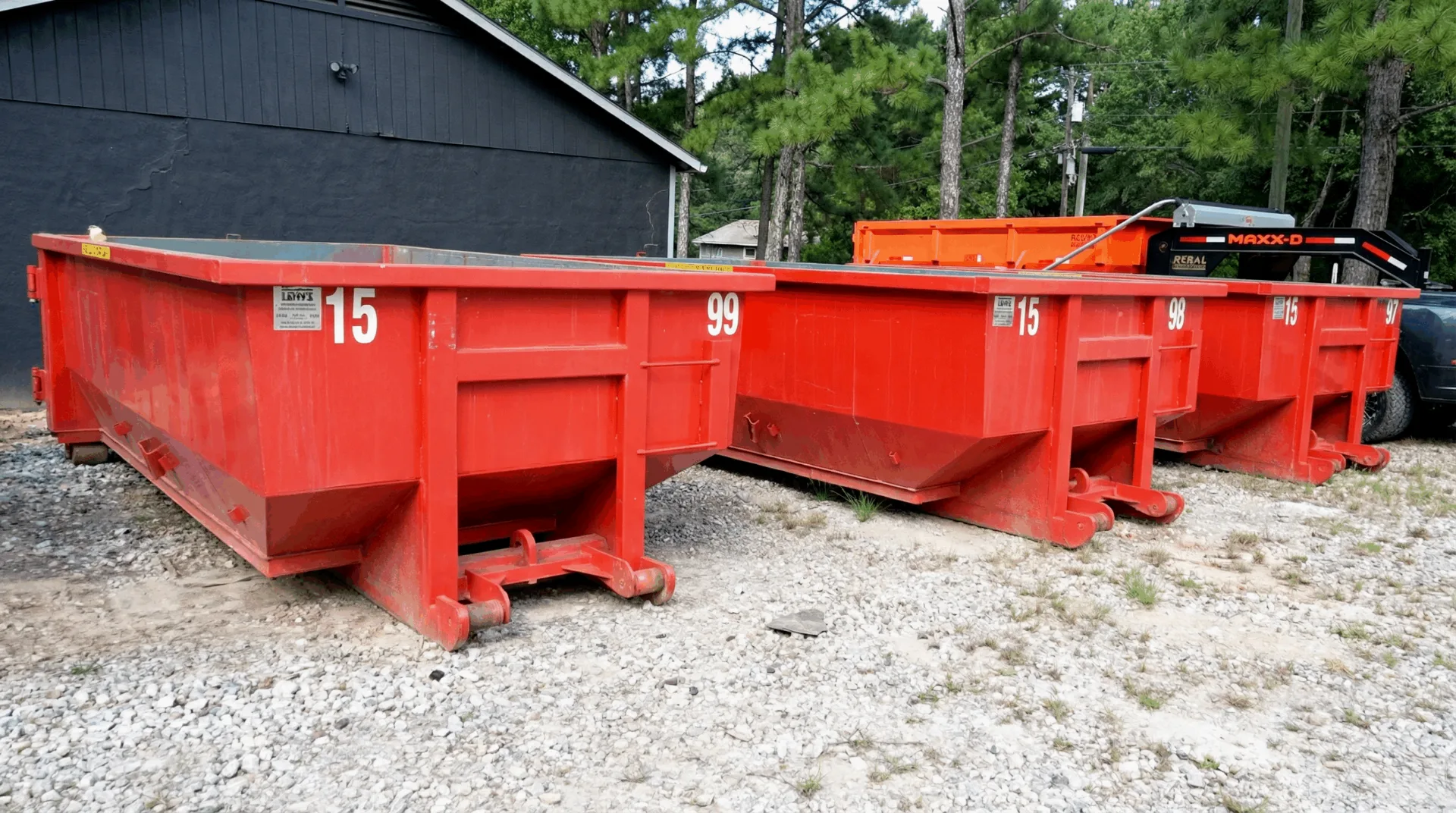 Red 15-yard roll-off dumpsters at the Haggai Dump and Haul yard in Griffin, GA